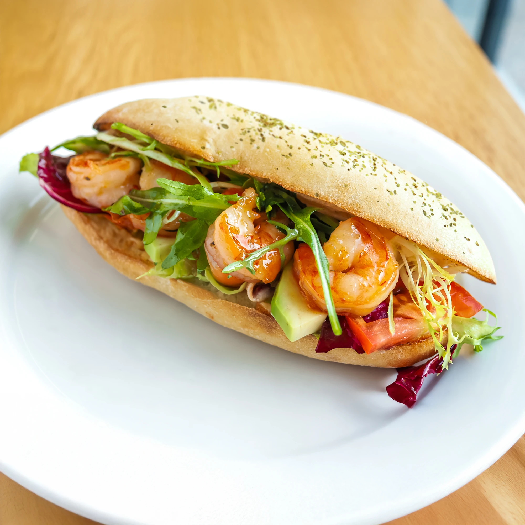 White Plate with a Cheese and herb Roll filled with Prawn, Avocado, Lettuce and Spring Onions 