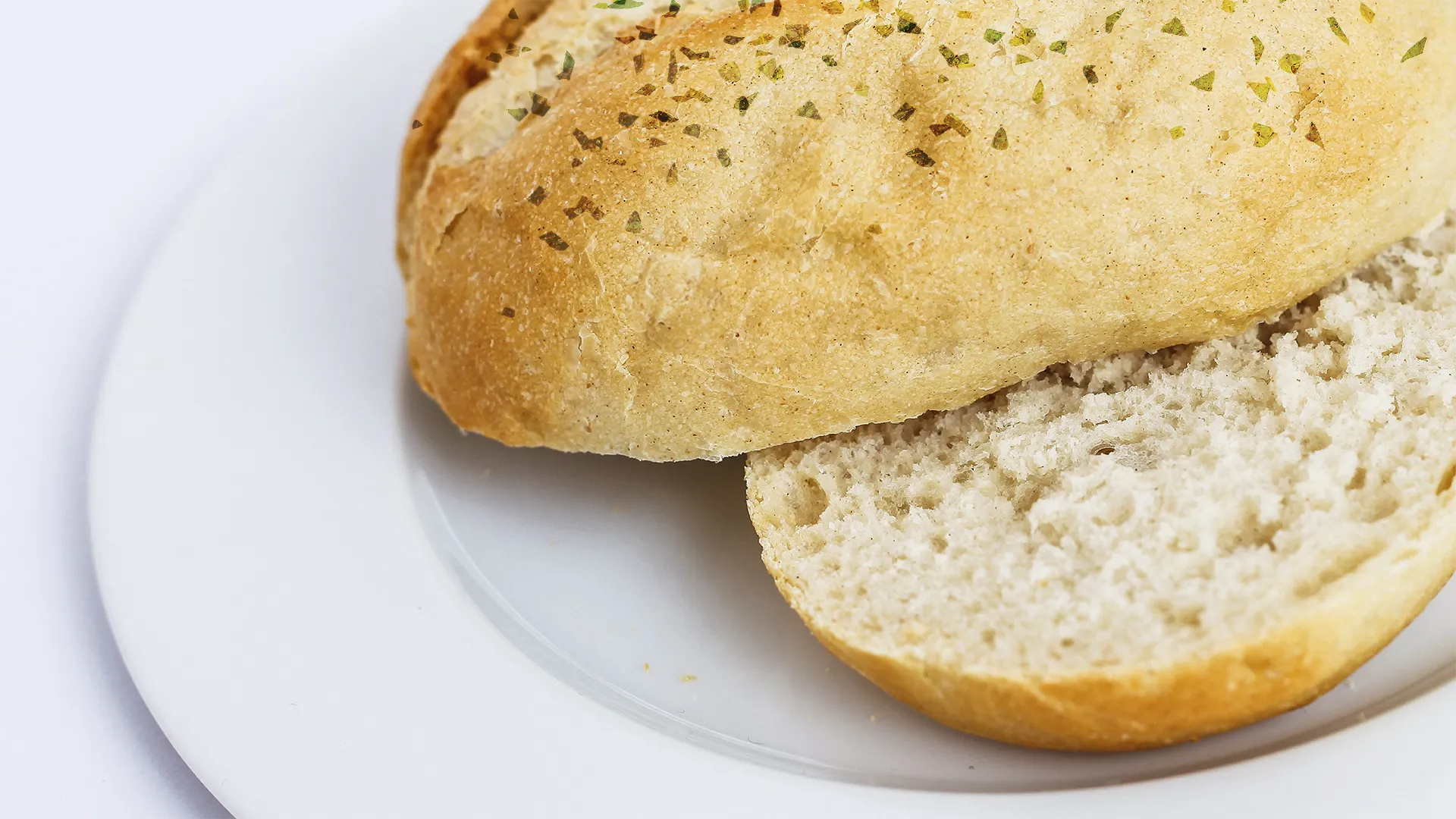 the top of a Honey and Sunflower sub roll sliced in half lengthways on a white plate 