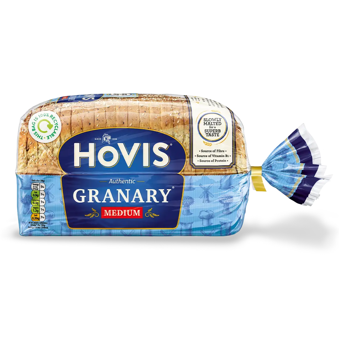 Hovis Granary Medium Sliced bread with a subtle shadow under it. The packaging is half transparent and half blue, decorated with images of mills, flour and wheat.