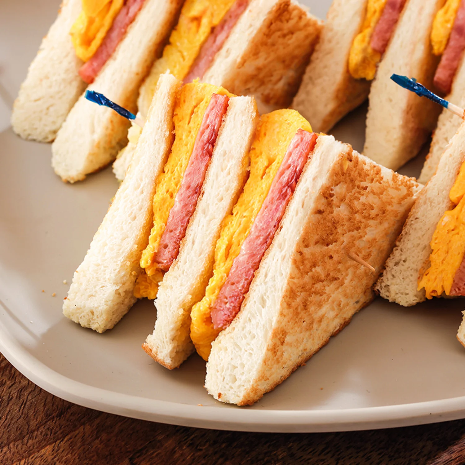 Close up of a Hong Kong style scrambled egg and spam sandwich on a plate.
