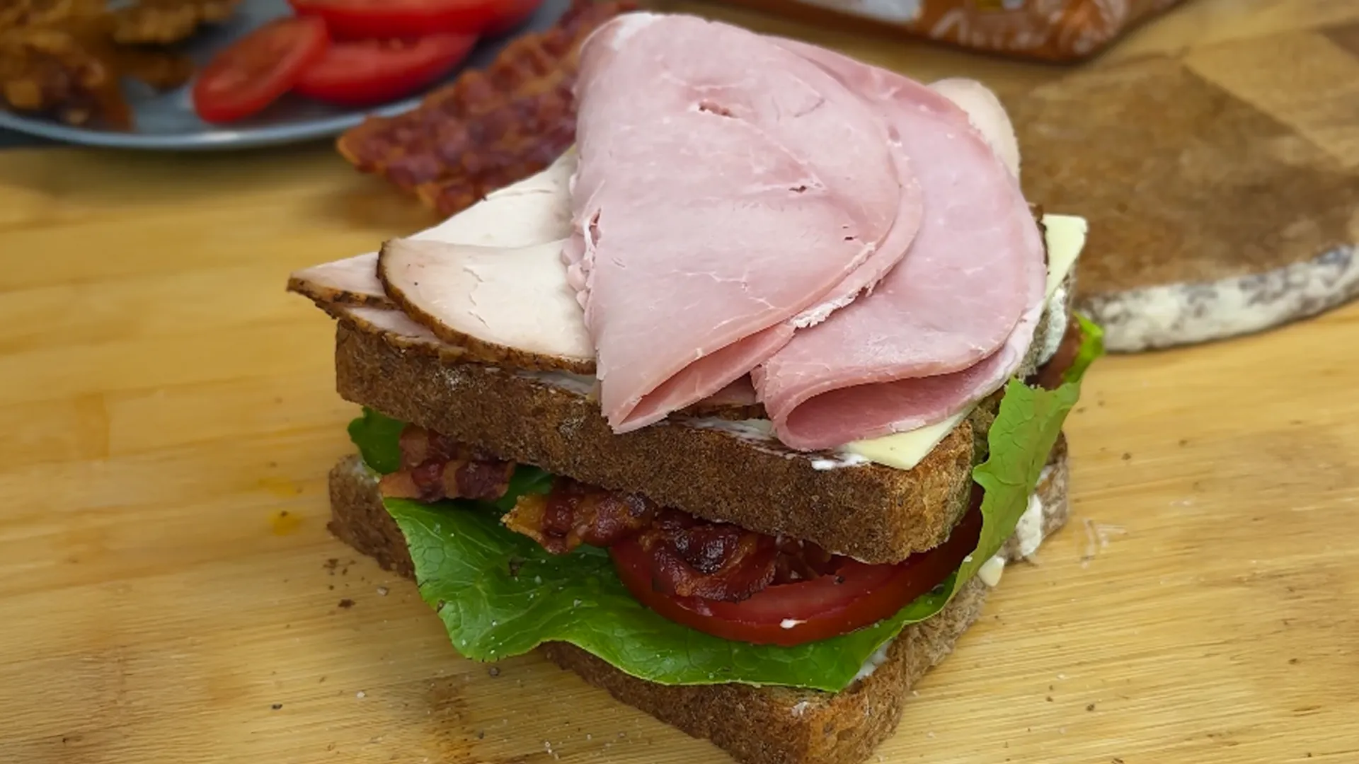 An image of the second layer of the club sandwich added on top of the first - this one with cheese, turkey and ham