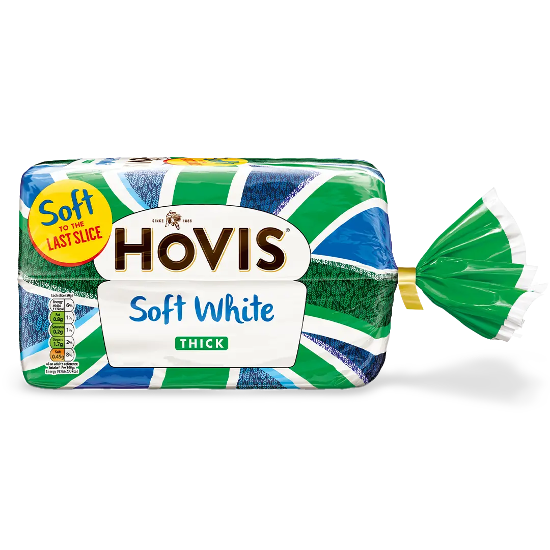 Hovis Soft White Thick Sliced bread with a subtle shadow under it. The packaging features a green Union Jack pattern and a yellow label reading 'Soft to the Last Slice.'