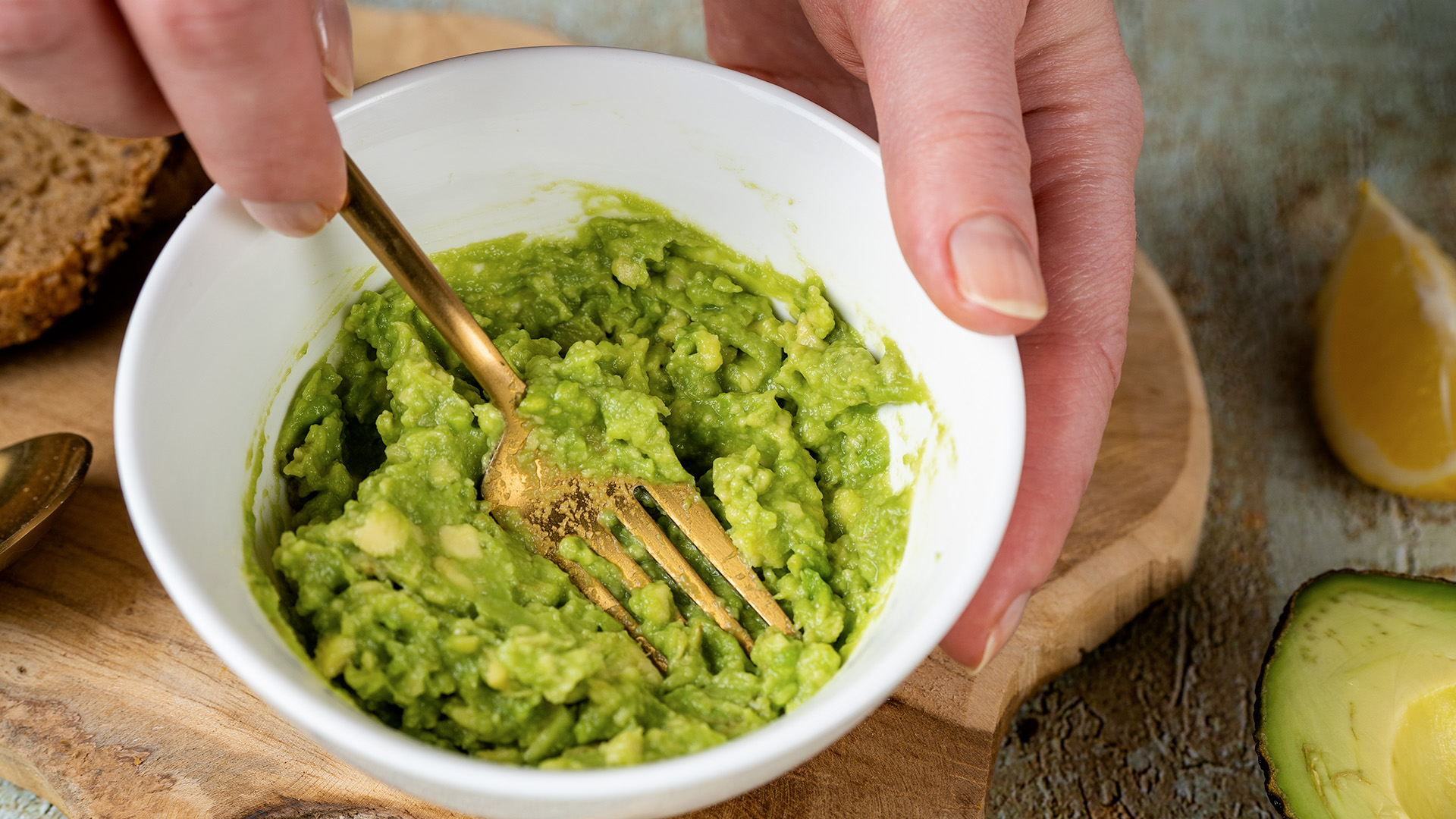 Someone smashing avocado up in a bowl with a fork 