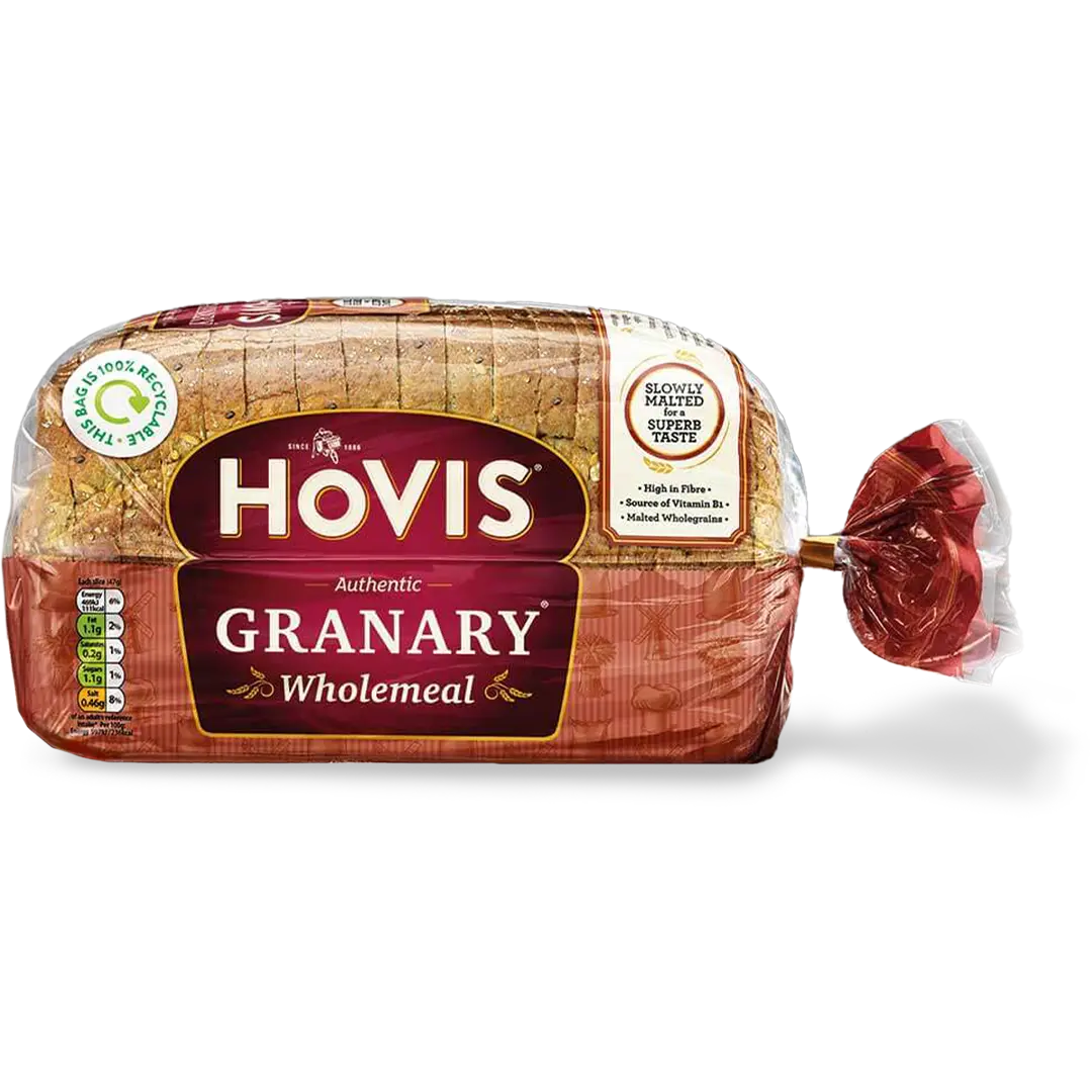 Hovis Granary Wholemeal bread with a subtle shadow under it. The packaging is half transparent and half red, decorated with images of mills, flour and wheat.