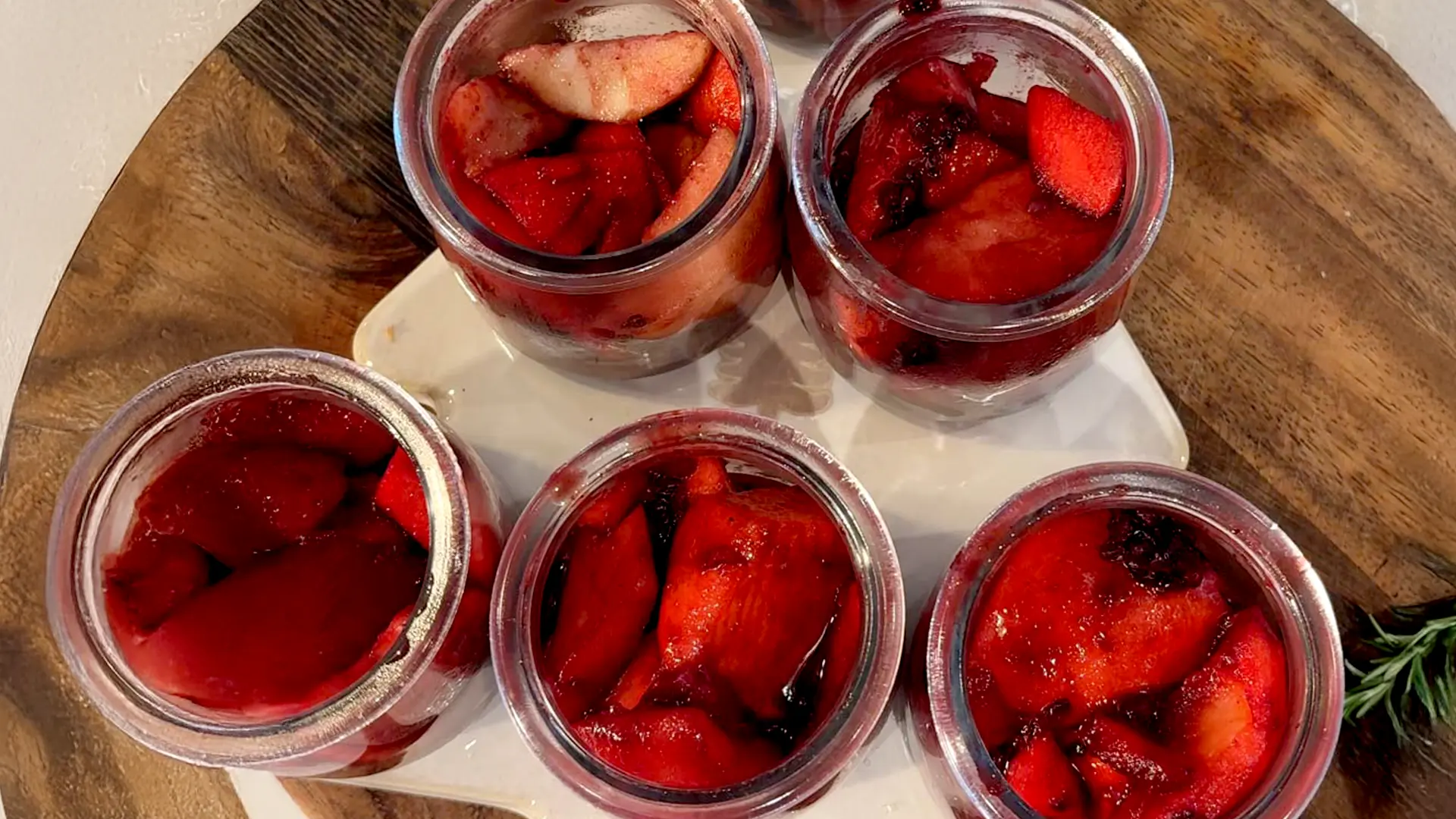 A close up shot of 5 pots filled with soft steamed apples, pears and berries mixed with sugar, cinnamon and nutmeg 