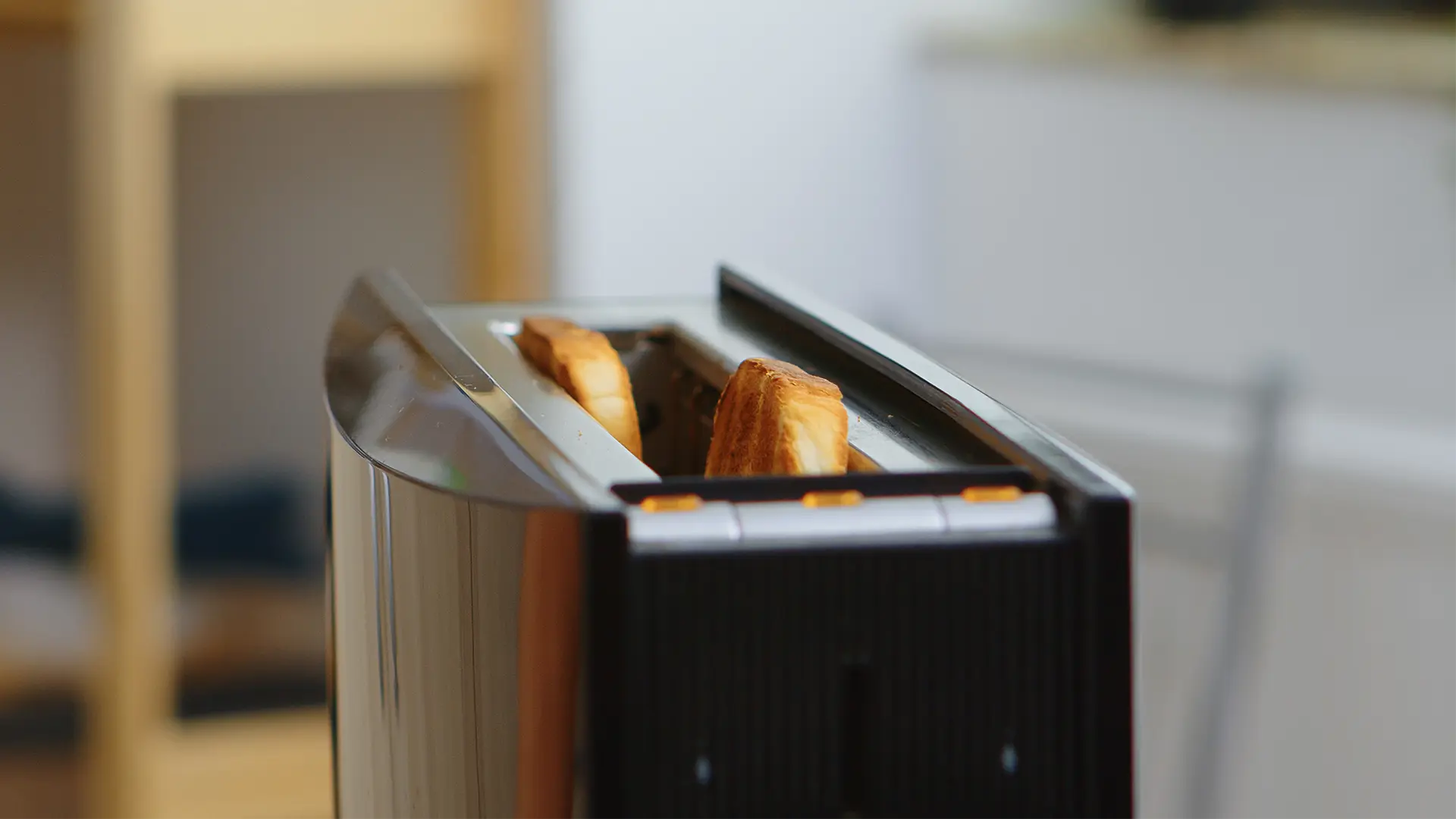 A close up image of Hovis White Cob slices in a modern toaster. In the background, a modern kitchen background.