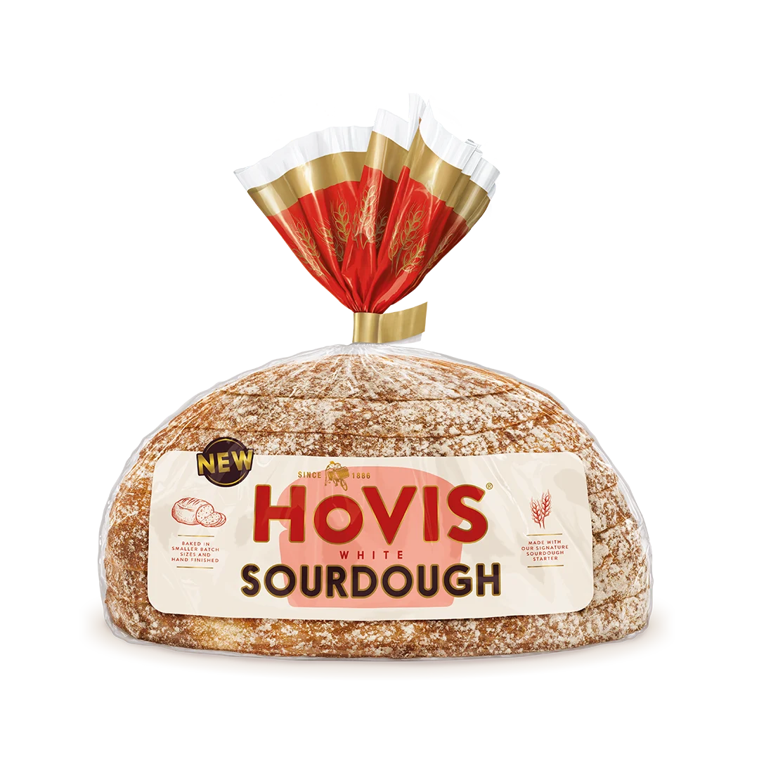 Hovis White Sourdough bread on a white backdrop with a subtle shadow. The packaging is half transparent and half light and dark red with gold detailing