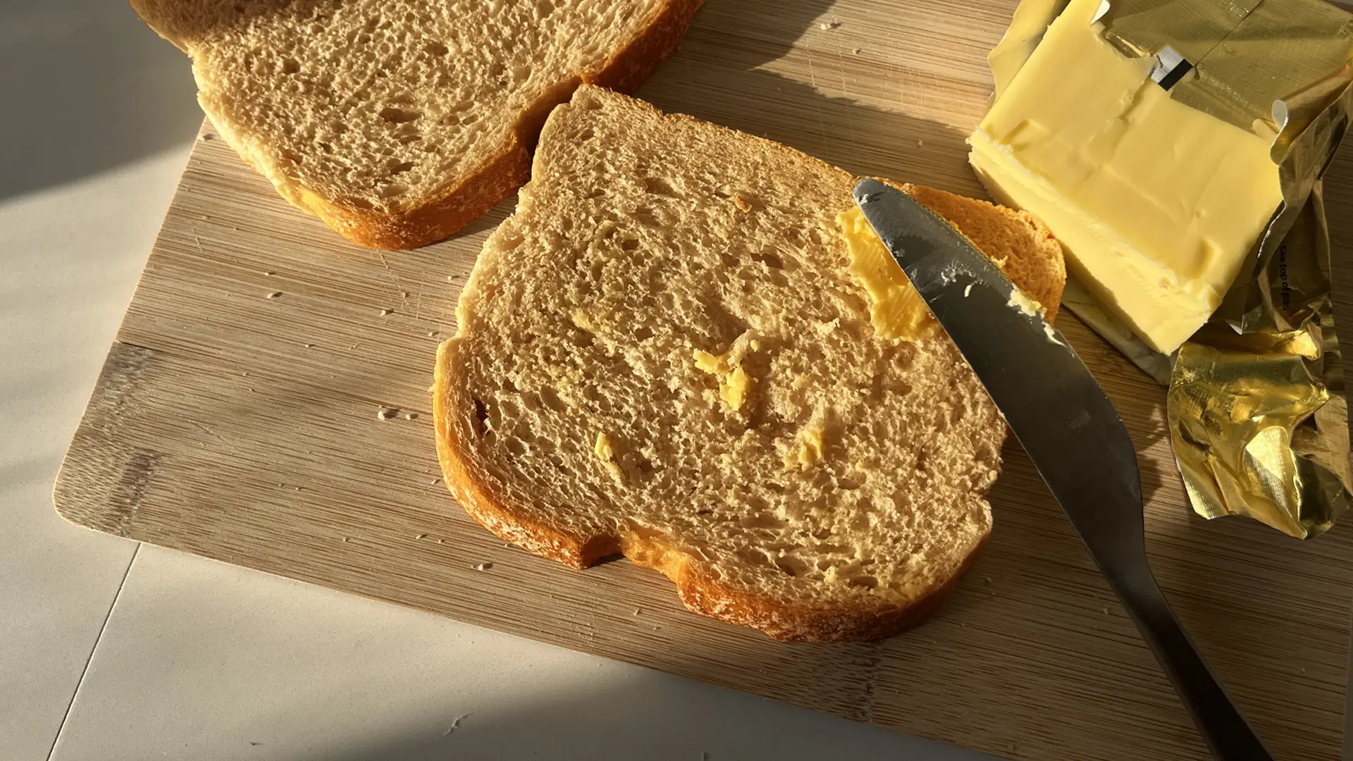 Someone spreading butter on a lightly toasted slice of Hovis® Farmhouse Batch Wholemeal
